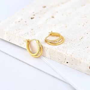 Macro detail of gold double hoop earrings featuring pavé set cubic zirconia accents