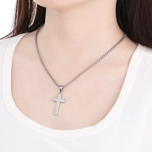 Polished silver stainless steel cross pendant necklace worn on a model's neck