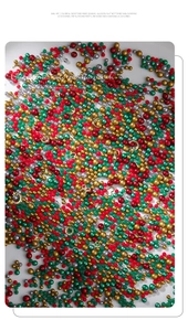 Macro view of Christmas nail art kit with colorful beads and gold metal charms