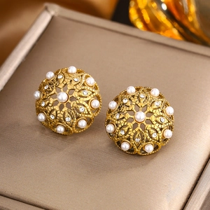 Vue macro de boucles d'oreilles vintage en or évidé avec perles et cristaux brillants