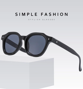 Detail view of square black sunglasses on white geometric cube for modern fashion aesthetic