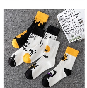 Close-up of Halloween socks with pumpkin, ghost and bat patterns on flat lay surface