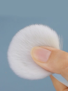 Close-up of soft white fiber bristles showing dense texture and elasticity on a makeup brush