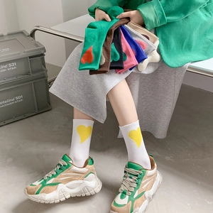 Mid-calf cotton socks with bold heart patterns in various macaron colors on a model