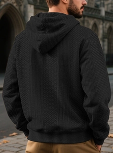 Detail of men's black hoodie featuring premium geometric jacquard knit texture from the back