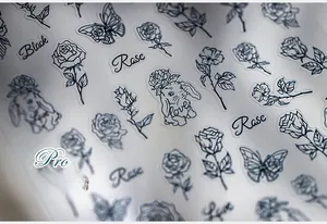 Détail macro de stickers pour ongles dessinés à la main avec roses noires, lapins et papillons