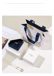 Elegant pearl white jewelry gift box set with navy ribbon handle and matching paper bag
