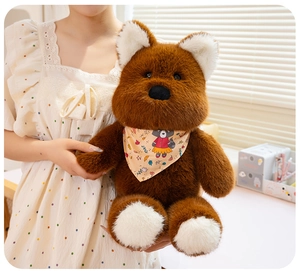 Close-up of soft brown plush bear toy with floral neck scarf held by a person