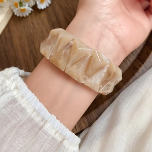 Detail of vintage acrylic triangle stretch bracelet with cream marble finish and wood texture