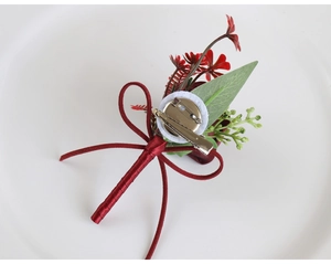 Detail of red rose corsage back with metal brooch pin and burgundy ribbon bow