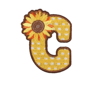 Yellow letter C embroidery patch with sunflower detail and brown edges on white background