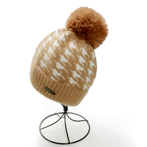Primo piano di un berretto in maglia pied de poule marrone e bianco con un pompon