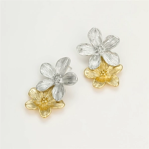 Détail de boucles d'oreilles pétales bicolores avec texture brossée or et argent