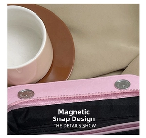 Detail of pink leather bag showing secure double magnetic closures and black lining interior