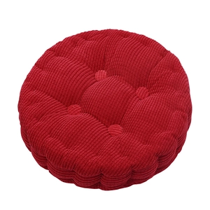 Detail of red circular corn velvet chair cushion with quilted five-point positioning