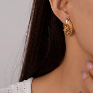 Detailed view of teardrop amber gem in vintage gold hollowed metal stud earring