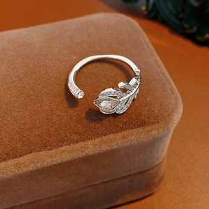 Gros plan sur la bague plume en argent sertie de zircons sur un écrin en velours