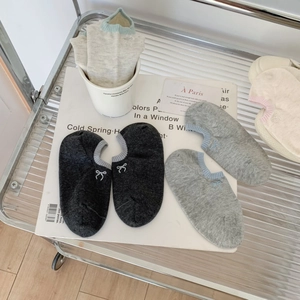 Detail of three pairs of thin low cut socks with elegant bow embroidery on white book