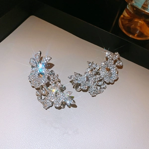 Macro view of silver floral ear clips with sparkling rhinestones in an elegant design