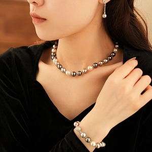 Close-up of elegant multi-color pearl necklace and matching earrings on a female model