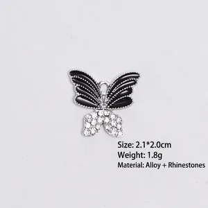 Detail view of alloy butterfly pendant with black enamel wings and sparkling rhinestones