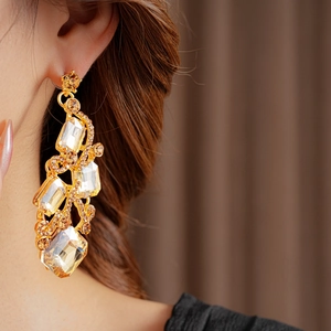 Close-up of elegant gold vintage tassel earrings with champagne rhinestones on a model