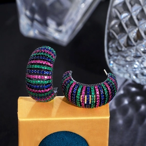 Close-up of C-shaped earrings with gradient zircon micro-inlay on black metal base