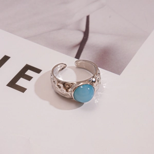 Détail de la bague réglable argentée avec texture martelée et incrustation de pierre bleue