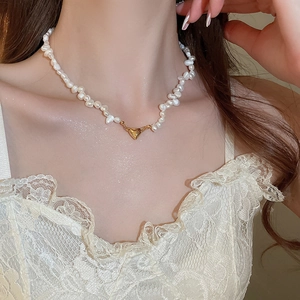 Detail of 18K gold heart pendant on baroque freshwater pearl beaded choker necklace