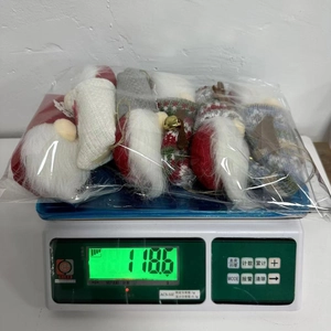 Detailed view of weighted Christmas gnomes set on a scale showing 118.6 grams