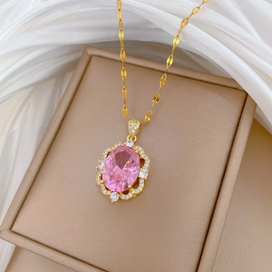 Detailed close-up of a titanium steel gold necklace featuring a pink oval gemstone pendant