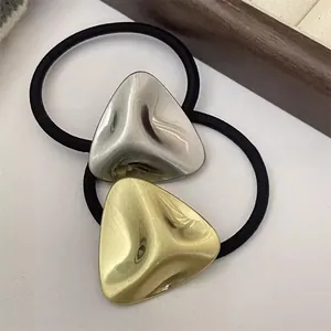 Detailed macro shot of minimalist geometric metal hair ties in gold and silver finishes
