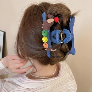 Vue détaillée de la pince à cheveux teckel en denim avec accents de boutons colorés