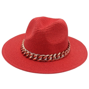 Vue détaillée d'un chapeau de paille Panama rouge avec une grosse chaîne en acrylique doré