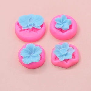 Set of four pink flower silicone baking molds with light blue floral cake decorations