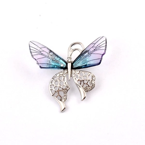 Detailed close-up of butterfly brooch with blue gradient wings and sparkling rhinestones