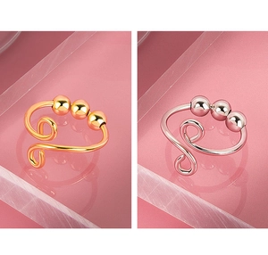 Detail view of gold and silver anxiety relief rings with movable beads and spiral metal design