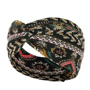 Close-up of black bohemian style yoga headband featuring a twist knot and paisley pattern