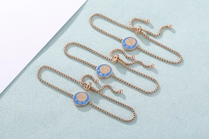 Dettaglio dei bracciali zodiacali in oro rosa con smalto blu e chiusura regolabile