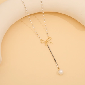 Detail der Y-förmigen Goldhalskette mit Perlenkette, Bogencharme und Quaste aus Strass