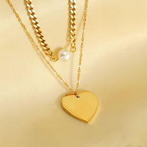 Double-layered gold necklace featuring a polished heart pendant and elegant white pearls