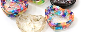 Detailed view of heart-shaped resin bowls with colorful crystal stones and gold flakes