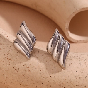 Macro shot of silver triple-layered flame earrings with a polished geometric finish