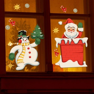 Detail of Christmas snowman and Santa window decals on a warm night home window