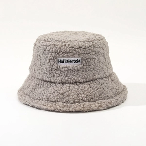 Detail of light grey lamb wool bucket hat with embroidered HaiTalentoM brand patch