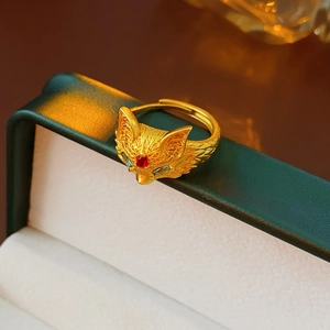 Detail of 24k gold plated fox ring showing intricate filigree and red gemstone inlay