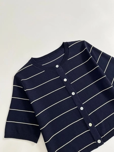Detailed flat lay of navy blue striped knit cardigan with white buttons and round neck