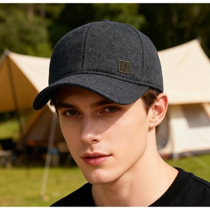 Close-up of dark grey wool texture baseball cap with antique bronze metal logo badge