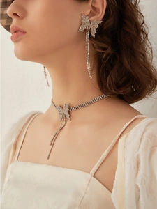Detail of silver rhinestone butterfly choker and earrings on model with elegant tassels