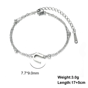 Detail of silver stainless steel double layer bracelet with letter U pendant and bead accents